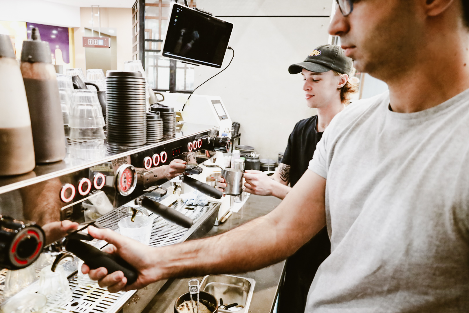 Baristas training together on the coffee machine