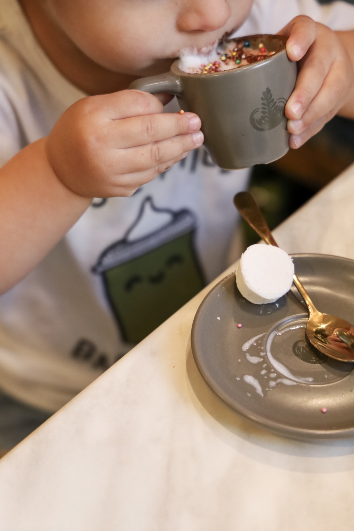 Little one sipping a frothy Babychino at Ariel's