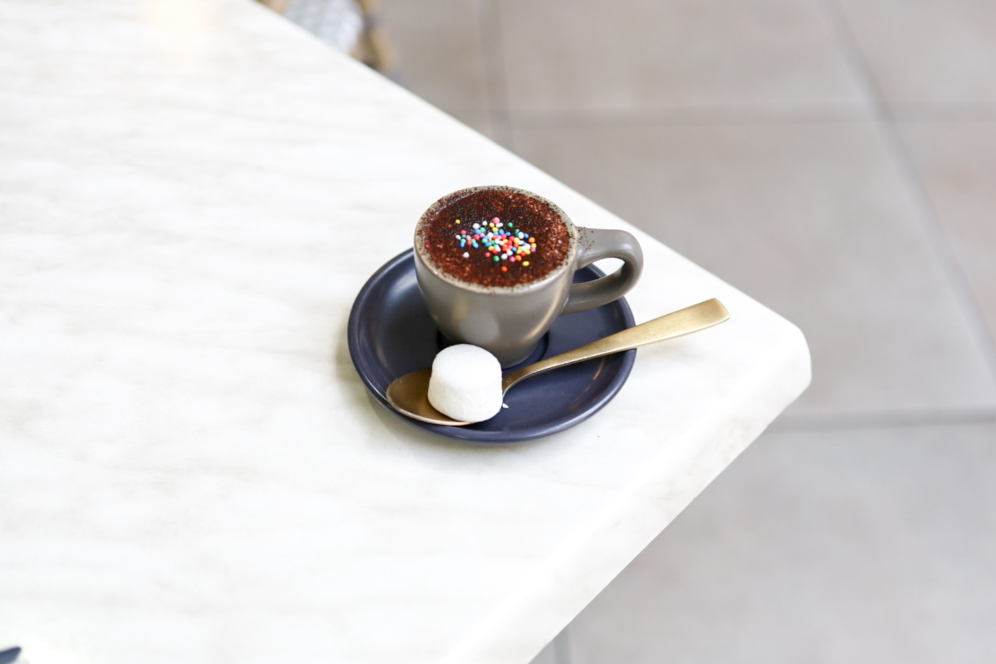 Babychino with a marshmallow on a marble table