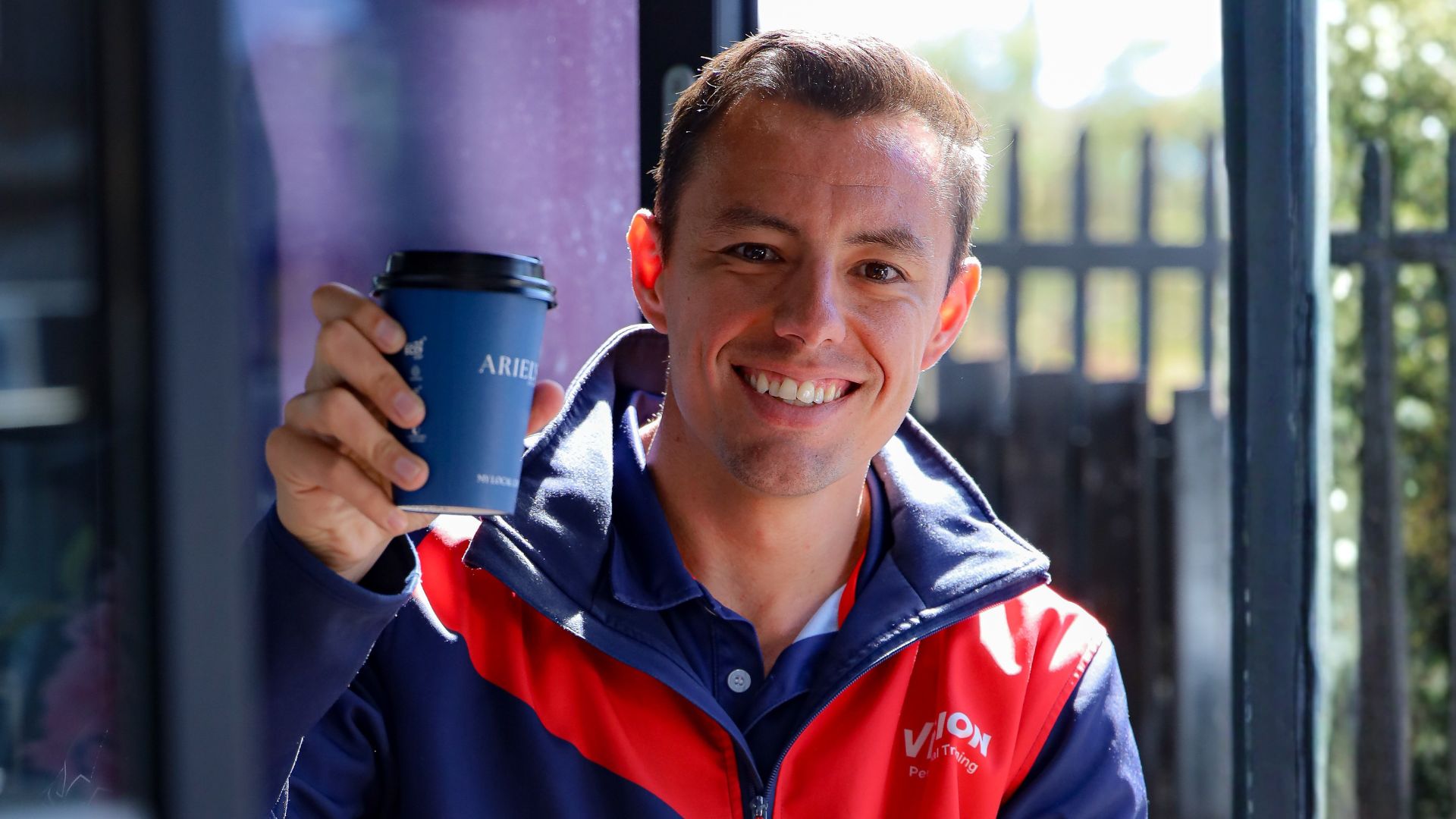 Personal trainer and gym member sharing a Campos coffee at a Vision Personal Training studio