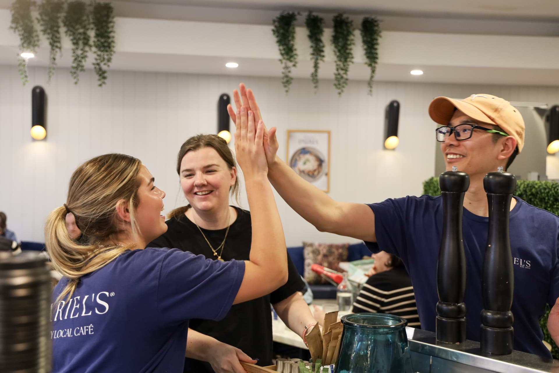 Ariel's team high-fiving behind the counter