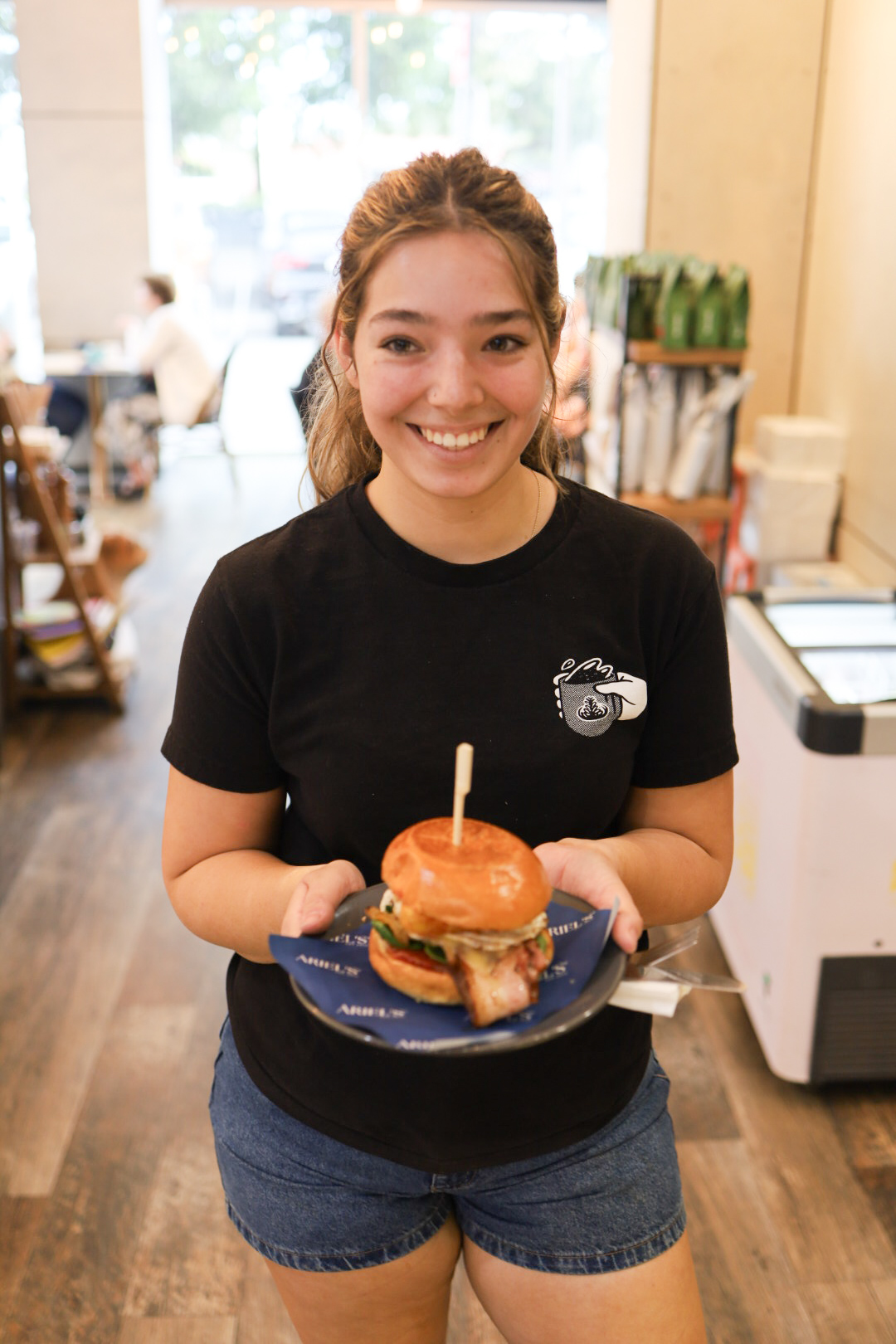 Team member presenting a burger to a customer