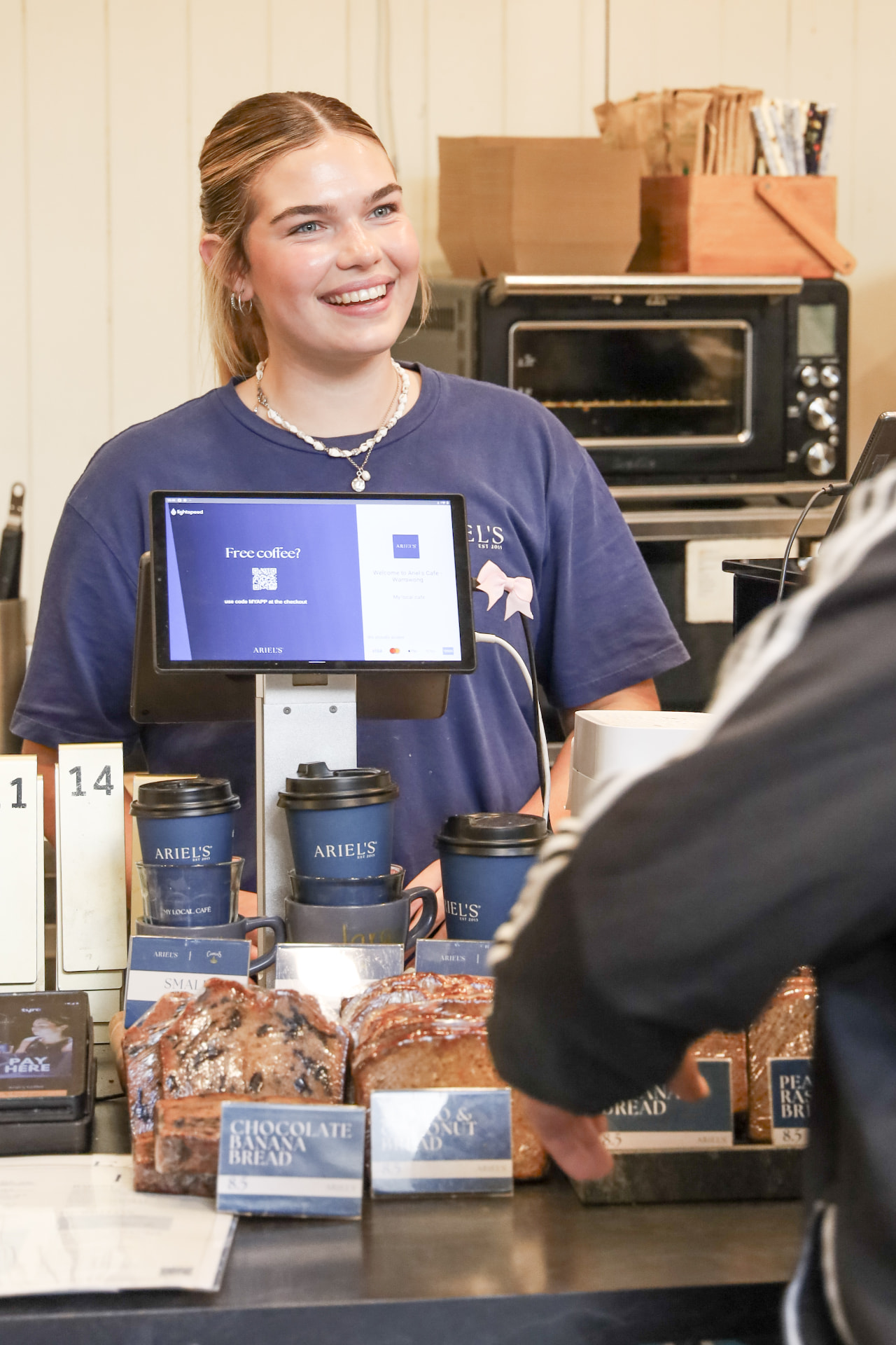 Smiling Ariel's team member serving at the counter