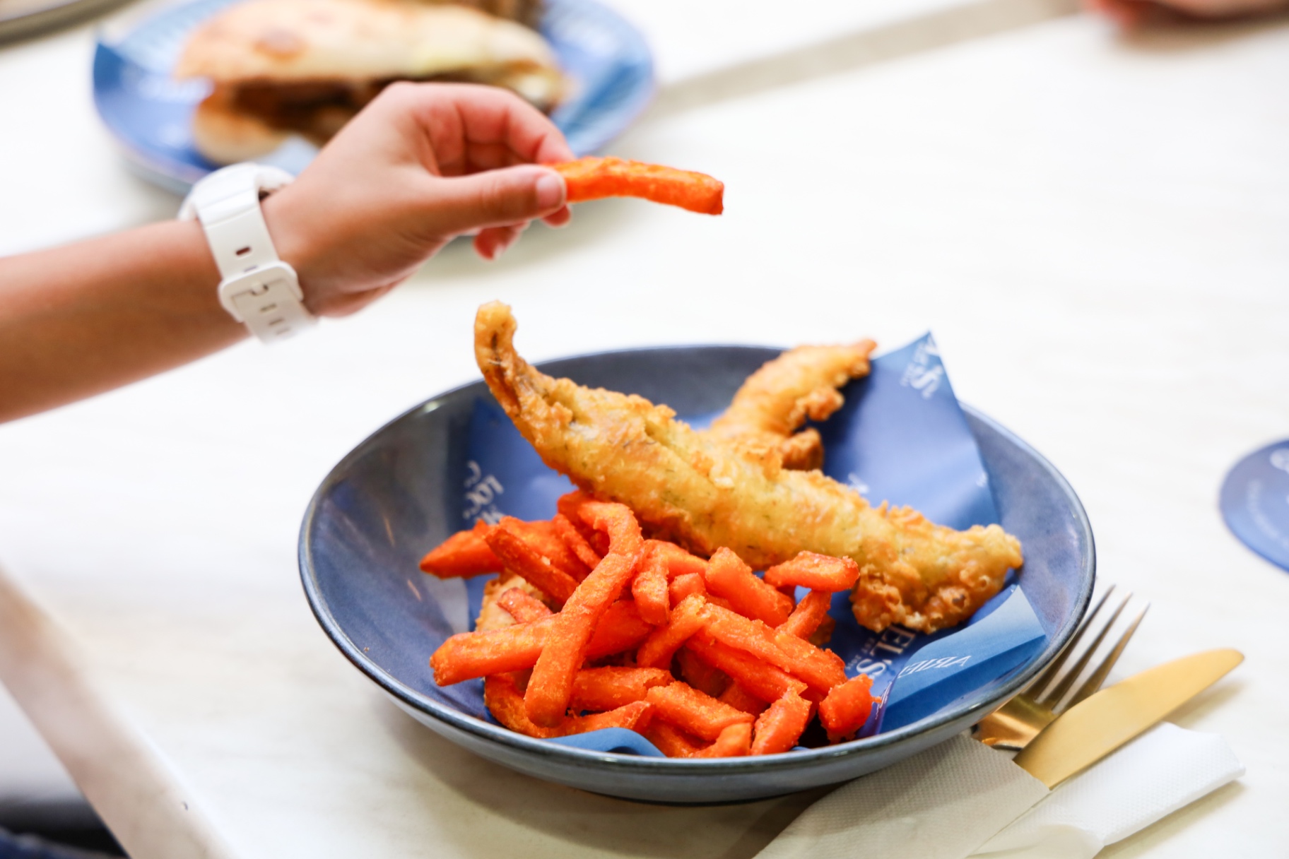 Fish and sweet potato fries on an Ariel's branded plate