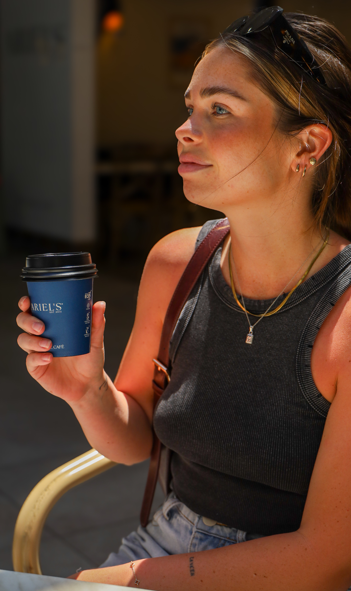 Customer with Ariel's signature navy takeaway cup