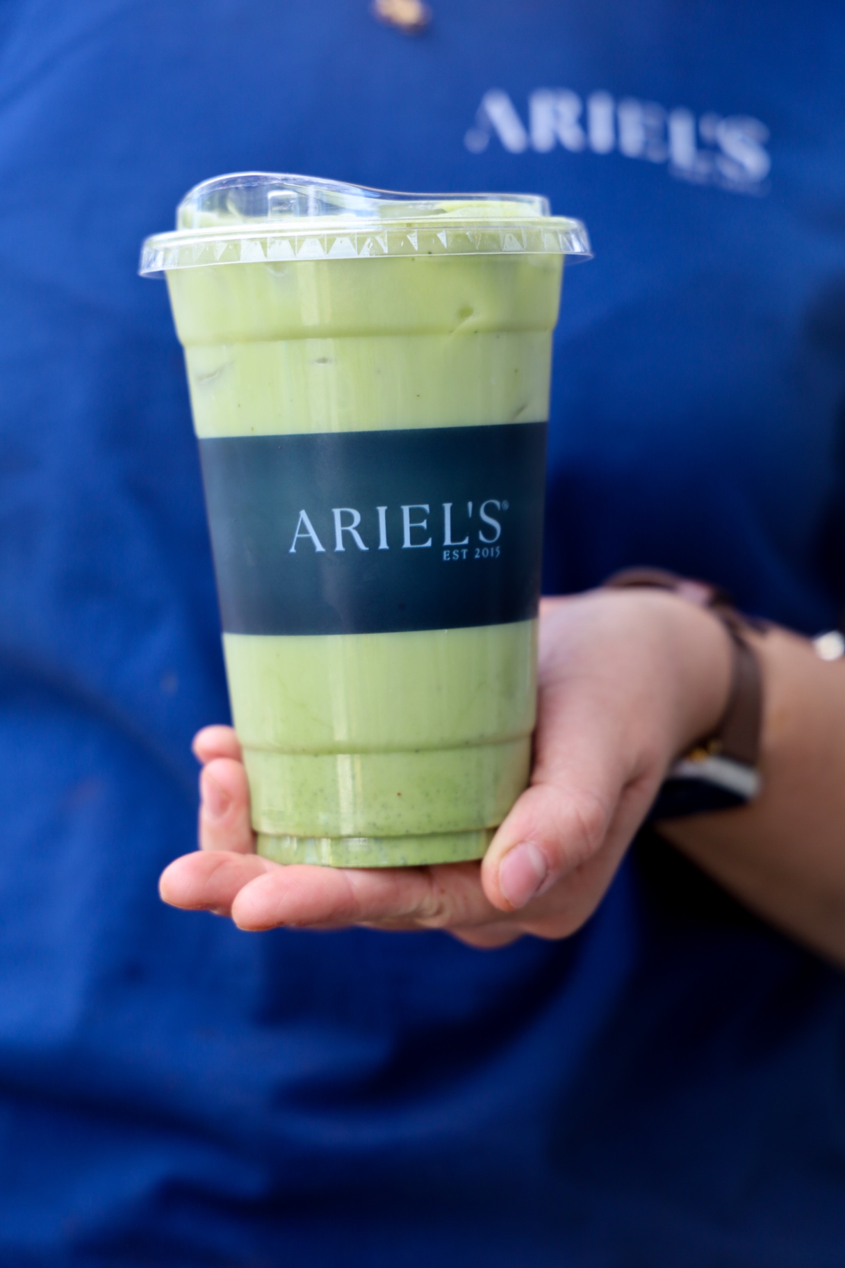 Iced matcha latte in an Ariel's branded cup